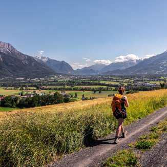 Hike with a view of the Rhine Valley Woman hiking on a dirt road with a panoramic view over the Rhine Valley in Liechtenstein