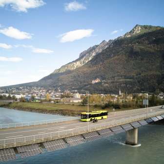 LIEmobil bus on the Rhine bridge in Vaduz - view of the Alps in Liechtenstein Yellow LIEmobil bus crosses the Rhine bridge near Vaduz with a mountain panorama in the background - Experience Liechtenstein
